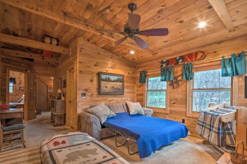 1 dormitorio en una cabaña de madera con 1 cama y ventilador de techo en Cozy Log Cabin Retreat Steps to Lake Lure and Beach, en Lake Lure