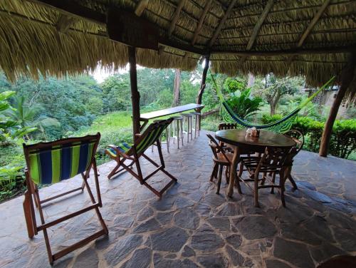 a patio with chairs and a table and a hammock at Eco-Lodge El Porvenir. in Santa Cruz