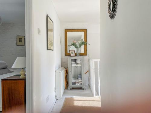 a hallway with white walls and a mirror at Greenhills Cottage in Shepton Mallet