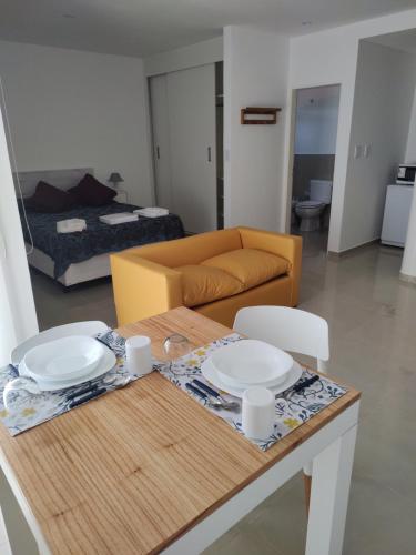 ein Wohnzimmer mit einem Tisch und einem Sofa in der Unterkunft Aspromonte Departamentos in La Plata