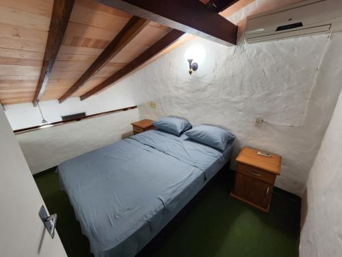 a small bedroom with a bed and a night stand at Departamento en San Bernardino - Barrio Cerrado in San Bernardino
