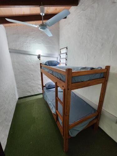 two bunk beds in a room with a ceiling fan at Departamento en San Bernardino - Barrio Cerrado in San Bernardino