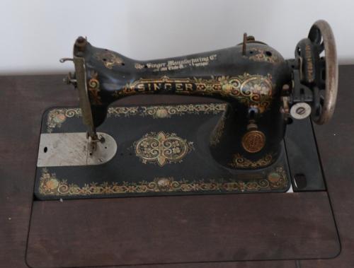 an old sewing machine sitting on top of a table at 1722 Chambres de Charmes in Ville-di-Paraso