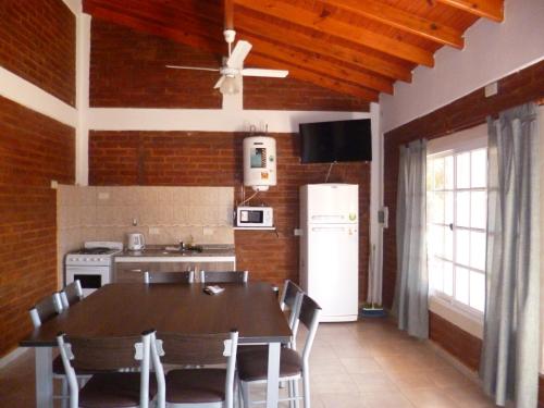 a kitchen with a table and a white refrigerator at Nuova Costa Cabañas in Los Molles