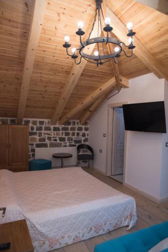 a bedroom with a bed in a room with wooden ceilings at Luxury Villa Saint Sofia in Voskopojë