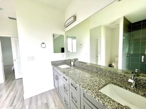 een badkamer met een grote wastafel en een grote spiegel bij New house with canal view in Cape Coral in Cape Coral