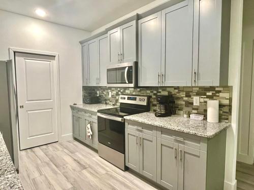 a kitchen with white cabinets and a stove top oven at New house with canal view in Cape Coral in Cape Coral