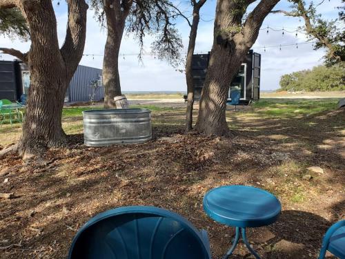 a blue stool and a barrel under two trees at TCR at 290 Wine Trail #13 Now dog friendly in Hye