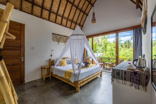 a bedroom with a bed with a hammock in it at Martas Windows in Kuta Lombok