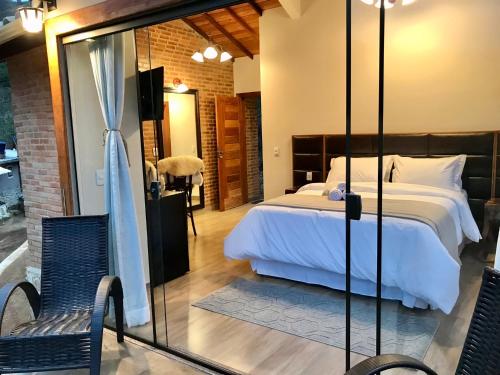 Habitación de hotel con cama y pared de cristal en Valle Piemonte, en Divisa