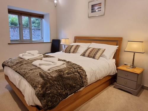 a bedroom with a large bed with towels on it at Mow Barton in Wells