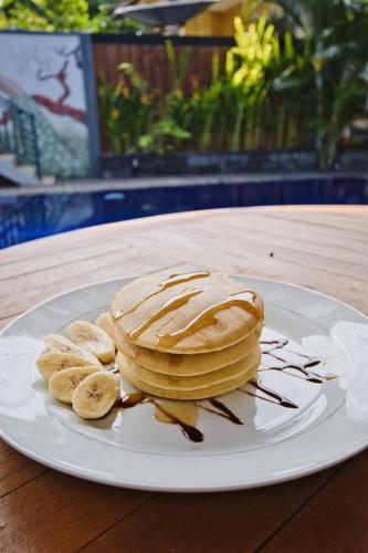 a plate with pancakes and bananas on a table at Dyou Villa in Nusa Penida