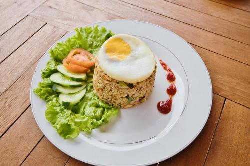 a white plate with a sandwich with an egg and salad at Dyou Villa in Nusa Penida