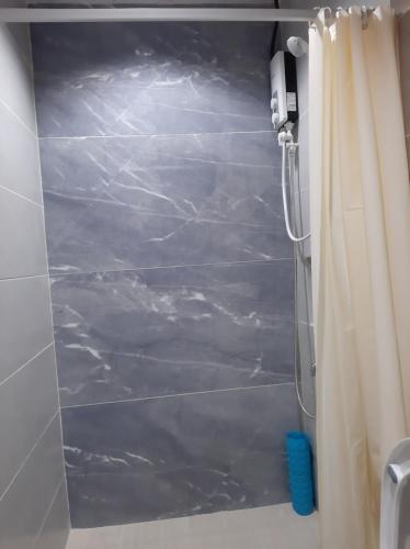 a shower in a bathroom with a shower curtain at M LILOAN PENSION HOUSE in Catarman