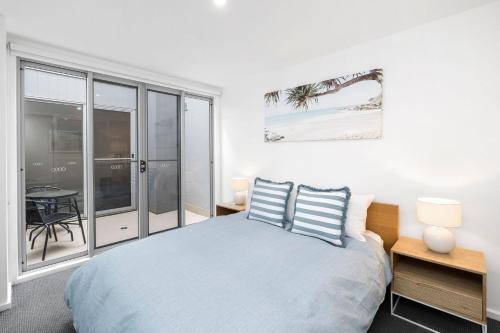 um quarto com uma cama com duas almofadas azuis em Villa Ishcia Apartment 1 em Lorne