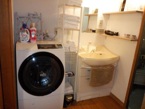 uma casa de banho com uma máquina de lavar roupa e um lavatório em Enako Villas em Takayama