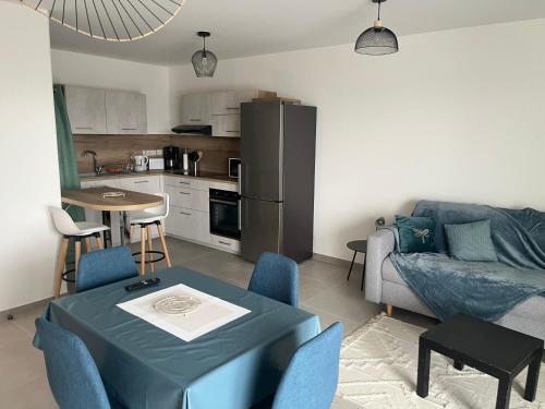 un salon avec un canapé et une table et une cuisine dans l'établissement Aurel's & Jul's - THE EMERALD GREEN Annecy, à Annecy