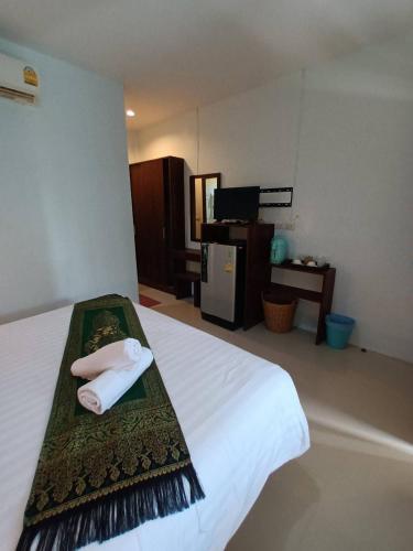 a hotel room with a bed with two towels on it at BaanPhong Lanta in Ko Lanta