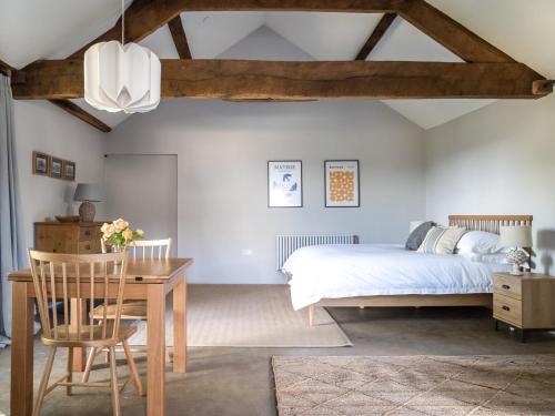 a bedroom with a bed and a table and a desk at Blackrock Barn in Clifford