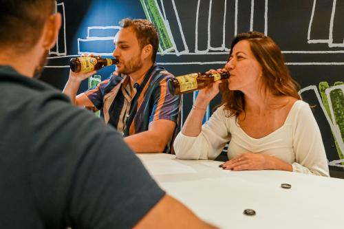a man and a woman drinking from beer bottles at ibis budget Santos Gonzaga in Santos