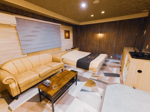 Cette chambre comprend un canapé, un lit et une table. dans l'établissement GLAMROSE -Adult Only-, à Gotemba