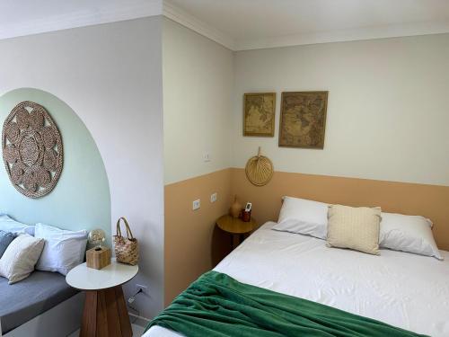 1 dormitorio con 1 cama con manta verde en Charmoso Apartamento em Maragogi, en Maragogi