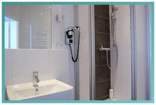 ein Bad mit einer Dusche und einem Waschbecken in der Unterkunft Gästehaus Küste in Nordenham