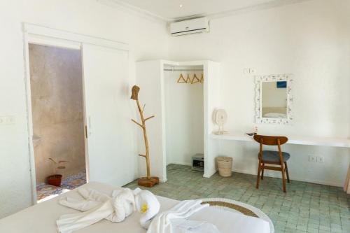 a white room with a bed and a desk at Surga Tropical Suites in Jimbaran