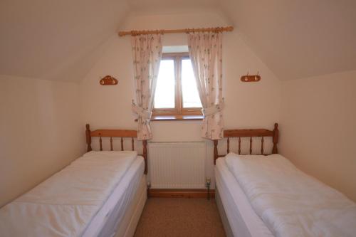 2 camas en una habitación pequeña con ventana en The Stables en Saint Helens