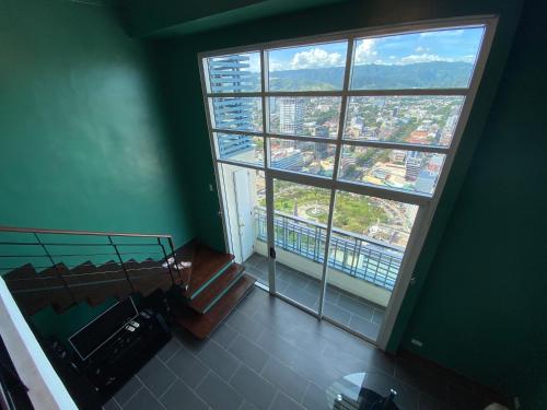 a room with a large window and a view of a city at Cebu City Huge Lofts by P&J in Cebu City