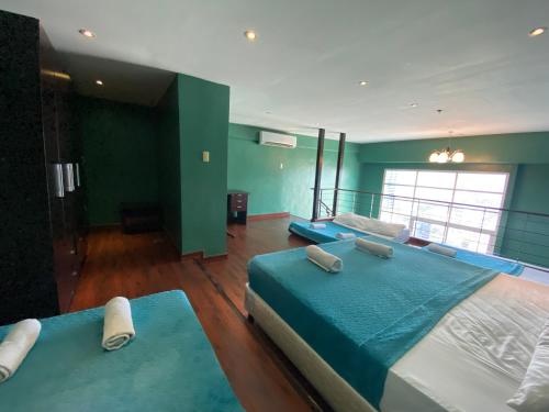 Cebu City Huge Lofts by P&J في مدينة سيبو: سريرين في غرفة بجدران خضراء