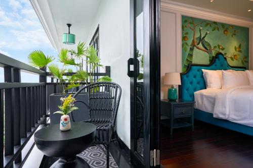 balkon z łóżkiem, stołem i krzesłem w obiekcie Hoi An Delicacy Hotel & Spa w Hoi An