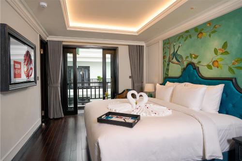 a hotel room with a bed with two swans on it at Hoi An Delicacy Hotel & Spa in Hoi An