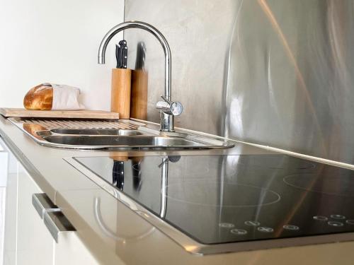 eine Küchenspüle aus Edelstahl mit einem Wasserhahn in der Unterkunft Blue on Blue Apartment 933 in Nelly Bay