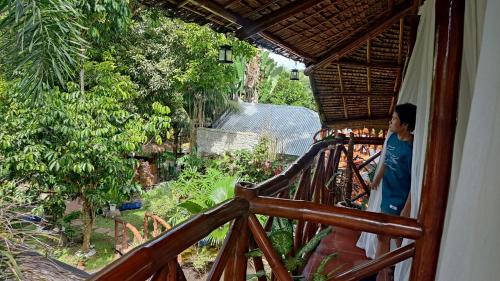 a man standing on a balcony of a house at GIARDINO ROMANTICO in Dumaguete