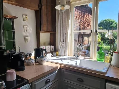 a kitchen with a sink and a window at Monk House - Historic Foundation Invites guests in Petworth