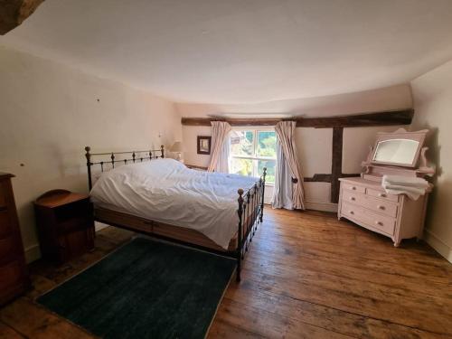 a bedroom with a bed and a dresser and a window at Monk House - Historic Foundation Invites guests in Petworth