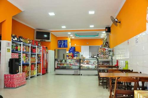 a grocery store aisle with tables and chairs in a store at Pousada do Gelão in Lagoinha