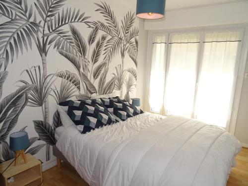 une chambre avec un lit avec un papier peint tropical dans l'établissement Appartement T2 avec loggia et parking, proche plage et commerces aux Sables d'Olonne - FR-1-92-912, à Les Sables-dʼOlonne