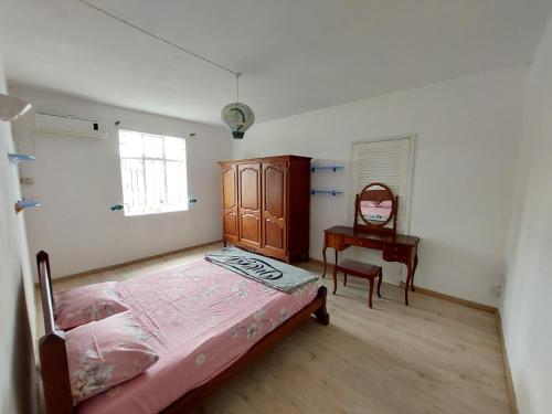 Schlafzimmer mit einem Bett, einem Schreibtisch und einem Stuhl in der Unterkunft hamdan retreat villa in Grand Baie