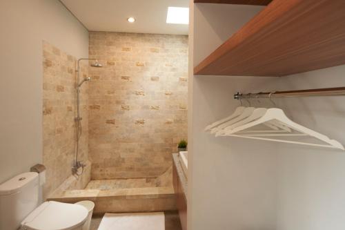 a bathroom with a shower and a toilet at Prema Uja Villas in Ubud