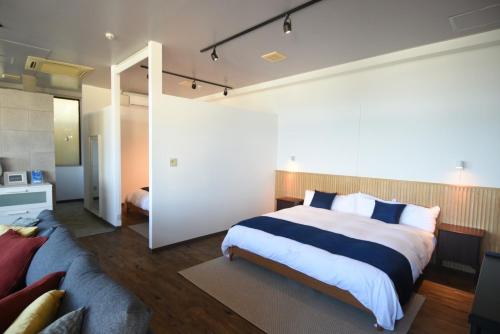 a bedroom with a large bed and a couch at FIRST STREET Okinawa Yomitan-son Oceans -SEVEN Hotels and Resorts- in Yomitan