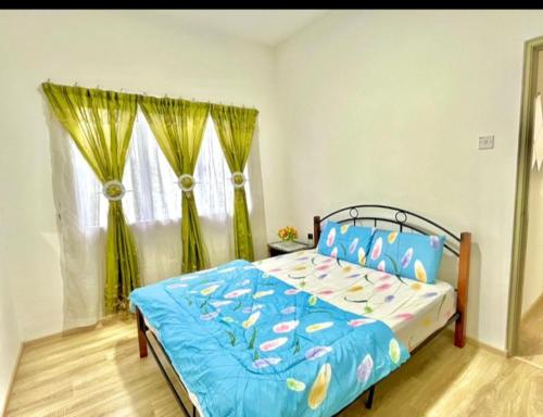 a bedroom with a bed with a blue comforter at Quintet Aparment in Tanah Rata