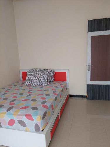 バトゥにあるVilla Beliciaのベッドルーム1室(カラフルな掛け布団付きのベッド1台付)