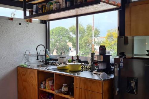 cocina con fregadero y ventana grande en Amazing Loft w/Terrace and Jacuzzi, en Ciudad de México