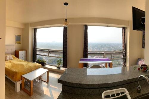 sala de estar con 1 cama y 2 ventanas en México Querido Jardín, en Ciudad de México