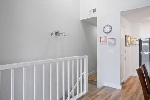 a white room with a staircase and a clock on the wall at Walk on the Ocean! Wake up to Beautiful Bay Views in Newport Beach
