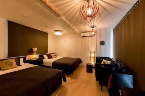 a hotel room with two beds and a chandelier at Hotel AIRSTAR in Fukuoka