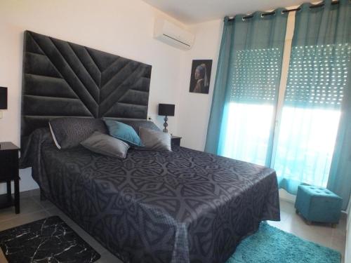 a bedroom with a large bed with blue curtains at Apartamento Roses, 2 dormitorios, 4 personas - ES-204-46 in Roses