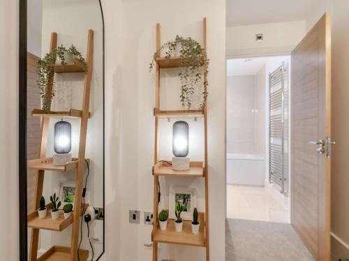a room with two shelves with plants and a door at Forest Acorn in Brockenhurst